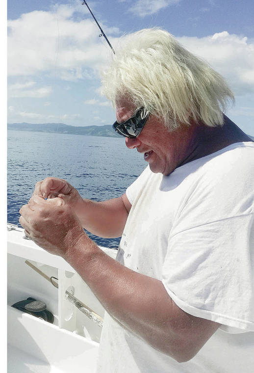 Captain John Llanes repairs his tackle;