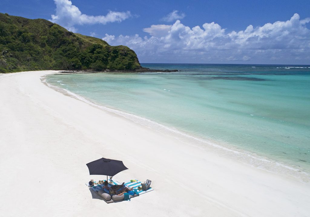 A Couple Relaxing on Pristine Beach A Couple Relaxing on Pristine Beach at Yasawa Island Resort